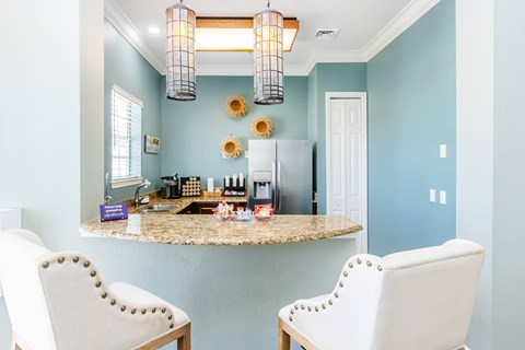 A kitchen with a table and two chairs.