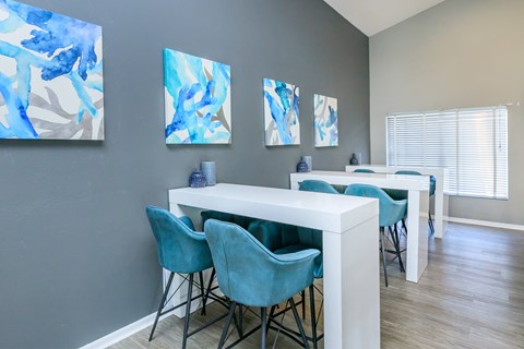 A dining room with a white table and blue chairs.