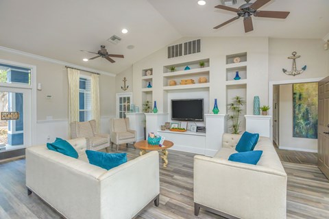 A living room with a white couch and a ceiling fan.