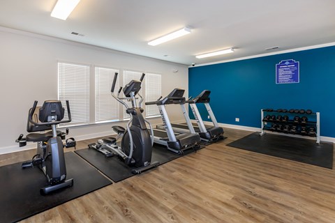 A gym with a blue wall and wooden floors.