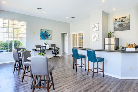 A modern kitchen with blue chairs and a wooden floor.