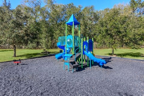A playground with a blue slide and a green tower.