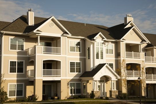 A large, multi-story residential building with a balcony on the second floor.