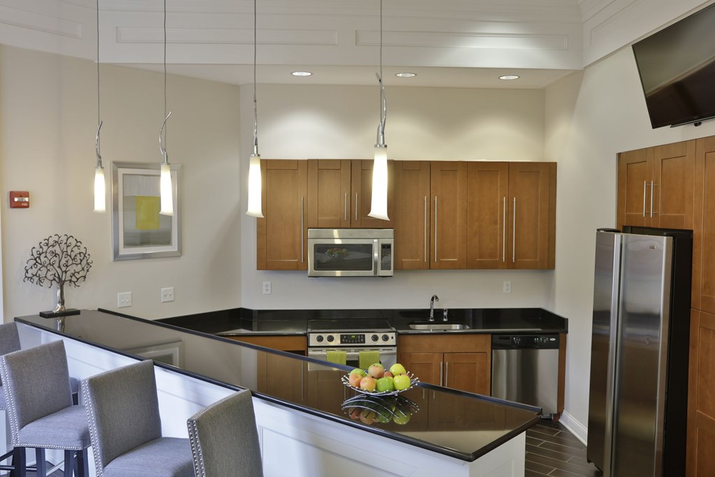 A modern kitchen with a black countertop and stainless steel appliances.