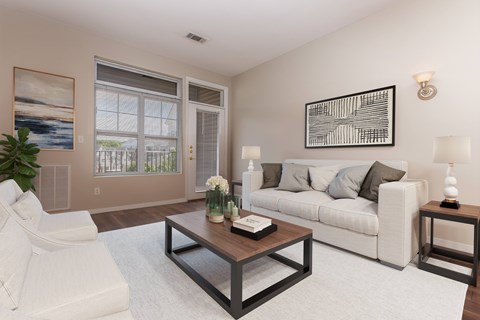A living room with a white couch, a coffee table, and a painting on the wall.