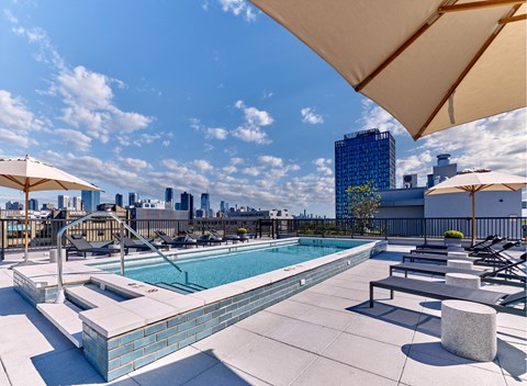A pool area with a view of the city skyline.