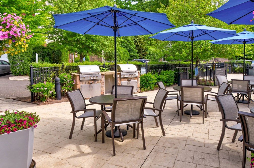 a patio with tables and chairs and umbrellas