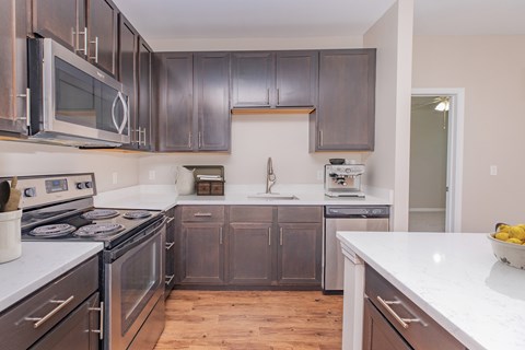 A kitchen with dark brown cabinets and stainless steel appliances.