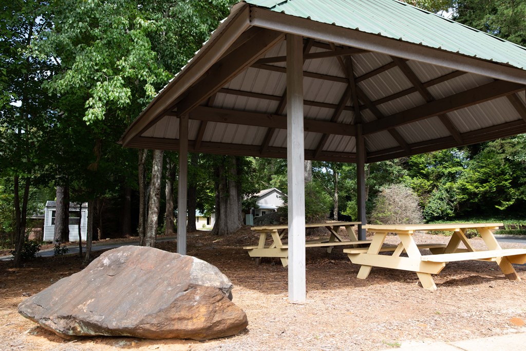 a picnic area with benches and a rock