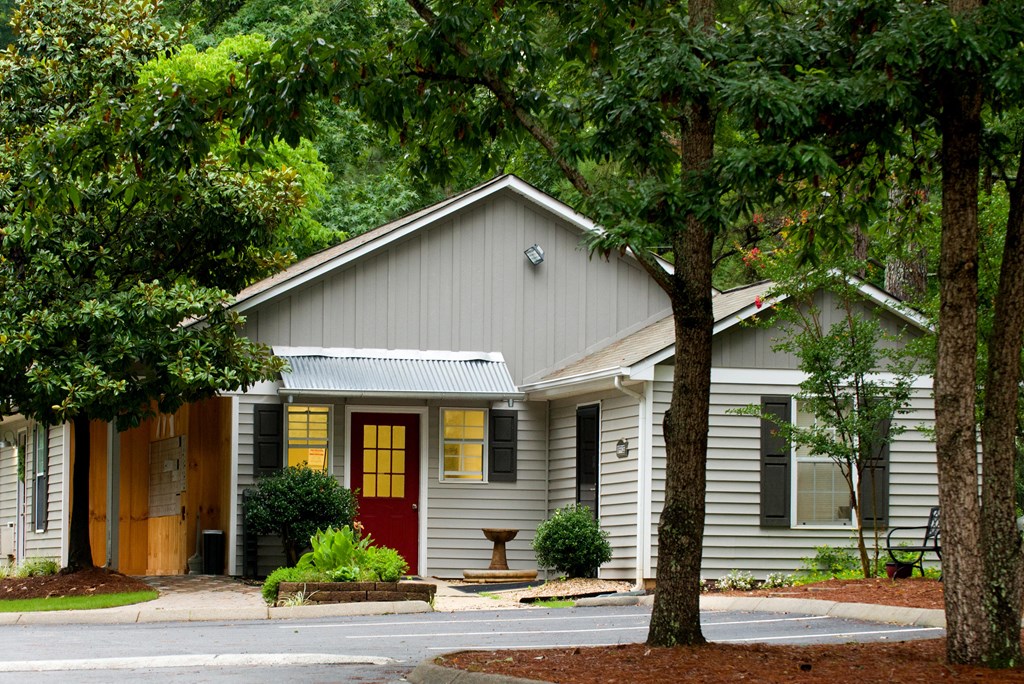 a small gray house with a red door