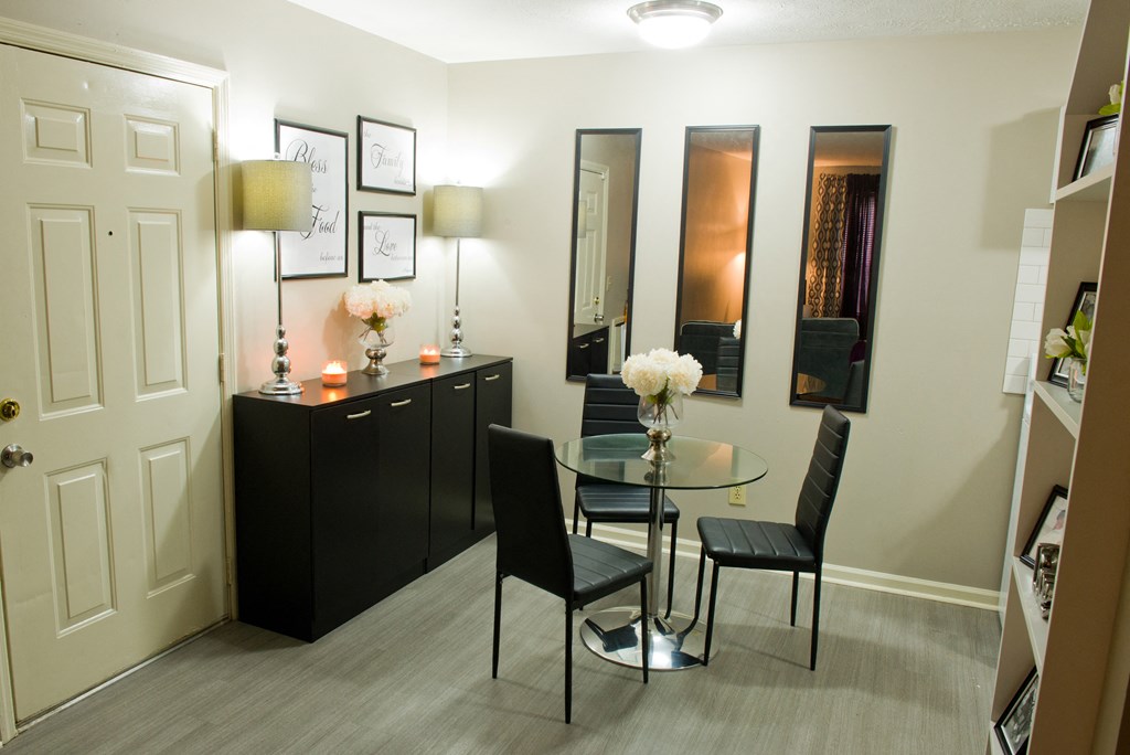 a small dining room with a glass table and black furniture