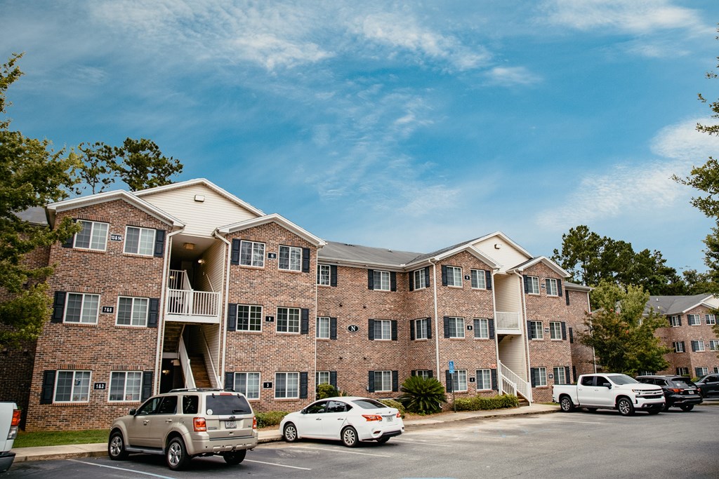 a large brick apartment building with cars parked outside