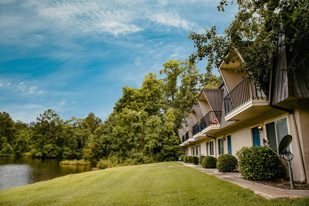 a building next to a body of water with trees