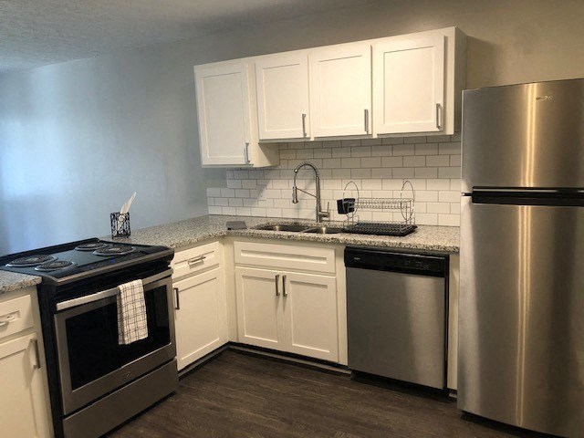 a kitchen with stainless steel appliances and white cabinets