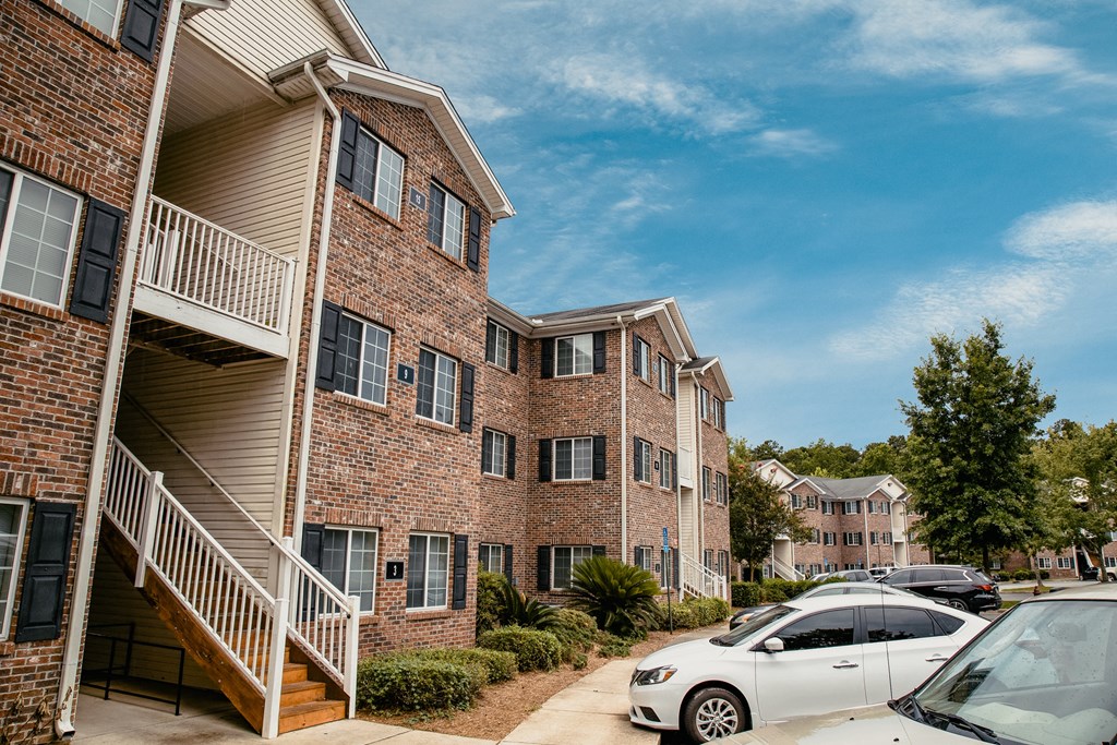an apartment building with cars parked outside of it