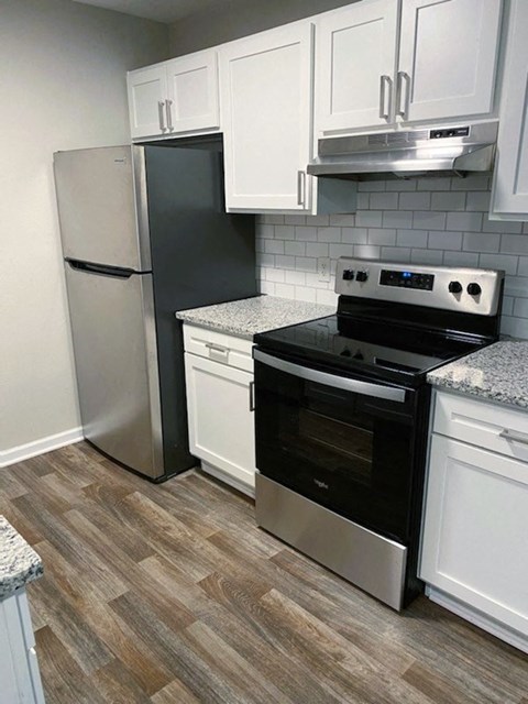 a kitchen with stainless steel appliances and white cabinets