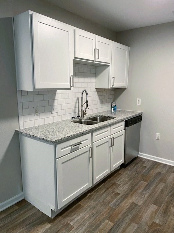 an empty kitchen with white cabinets and a sink