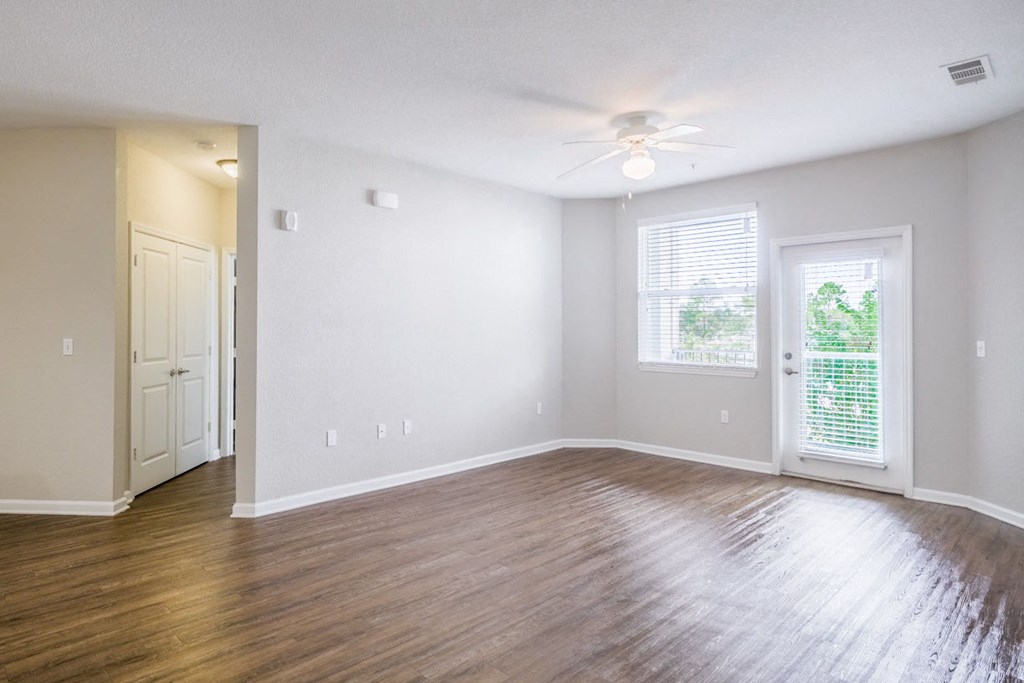 an empty living room with wood floors and a ceiling fan at Linden on the GreeneWay, Orlando