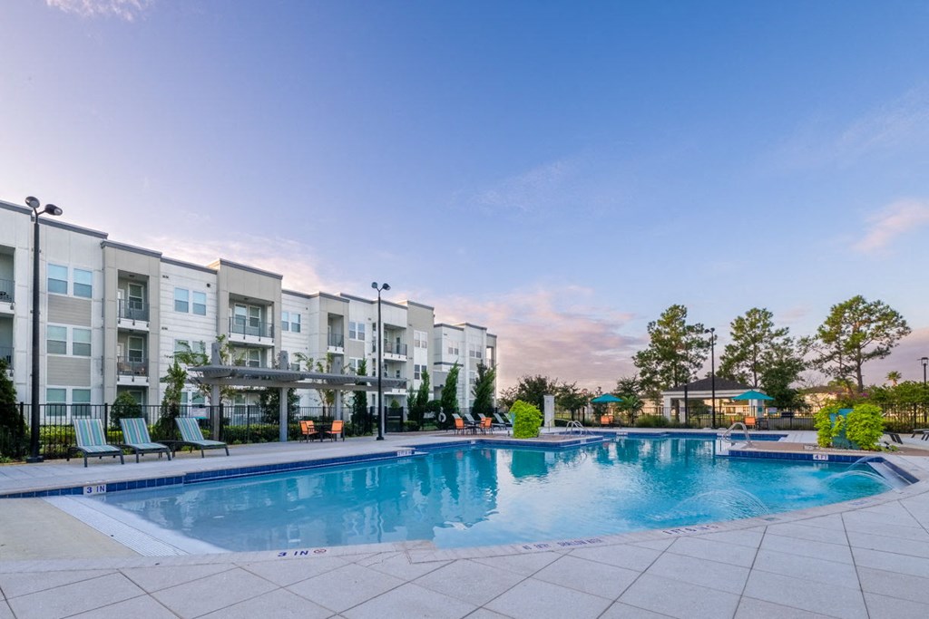 a swimming pool with an apartment building in the background at Linden on the GreeneWay, Florida, 32824