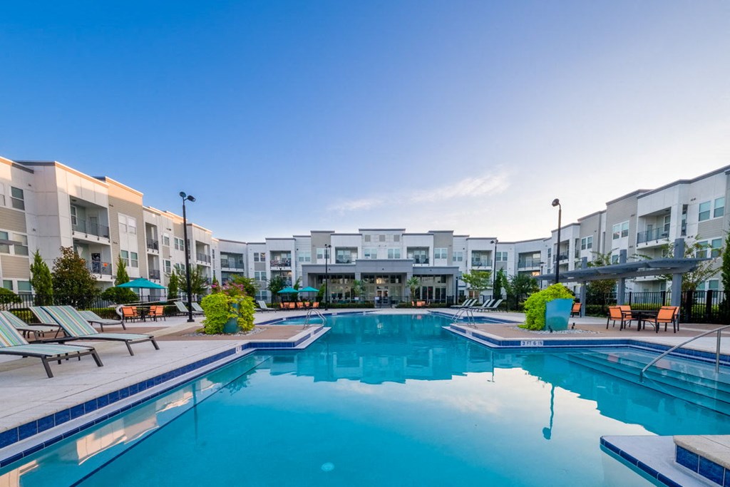 a swimming pool with an apartment building in the background at Linden on the GreeneWay, Florida