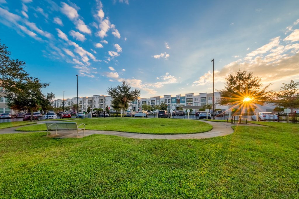 a park with green grass and a sunset in the background at Linden on the GreeneWay, Orlando