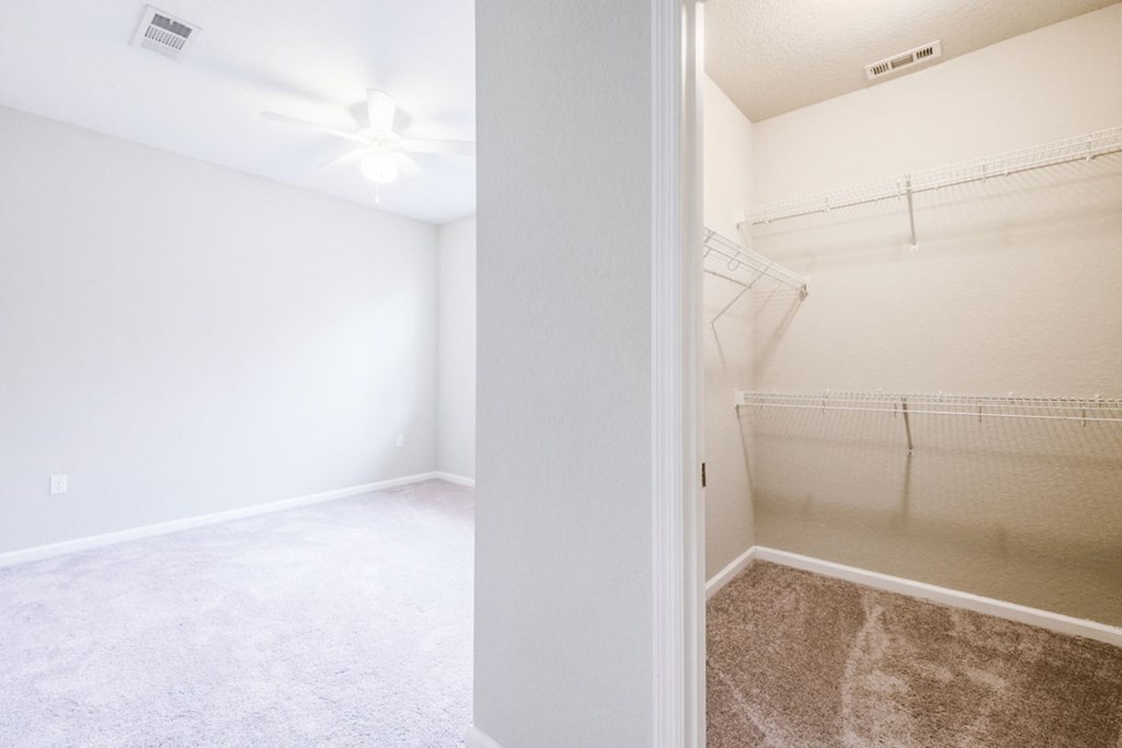 an empty bedroom with a mirrored closet and a ceiling fan at Linden on the GreeneWay, Florida