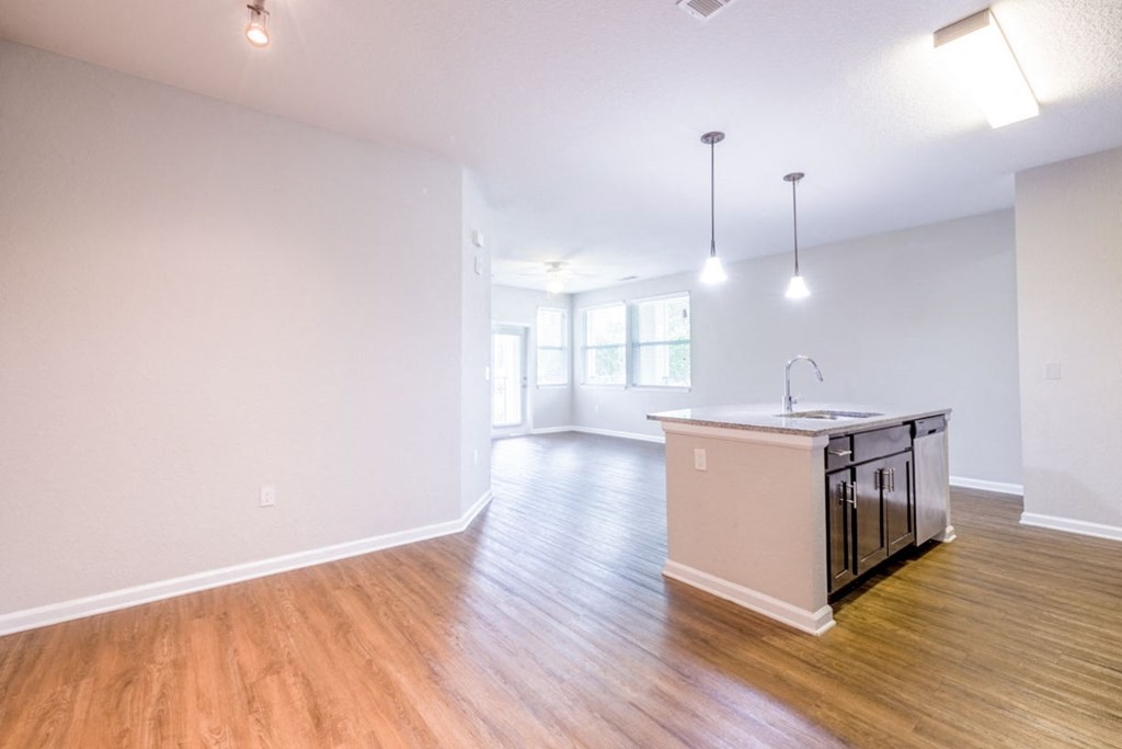 an empty living room and kitchen with a counter top in the middle at Linden on the GreeneWay, Orlando