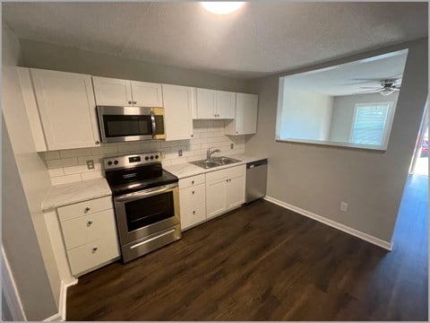 a kitchen with white cabinets and stainless steel appliances