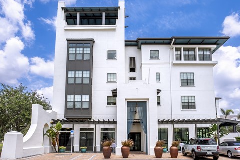 a large white building with cars parked in front of it at Azul Baldwin Park, Florida
