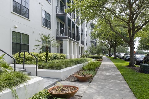 a city sidewalk in front of a building with trees and plants at Azul Baldwin Park, Orlando