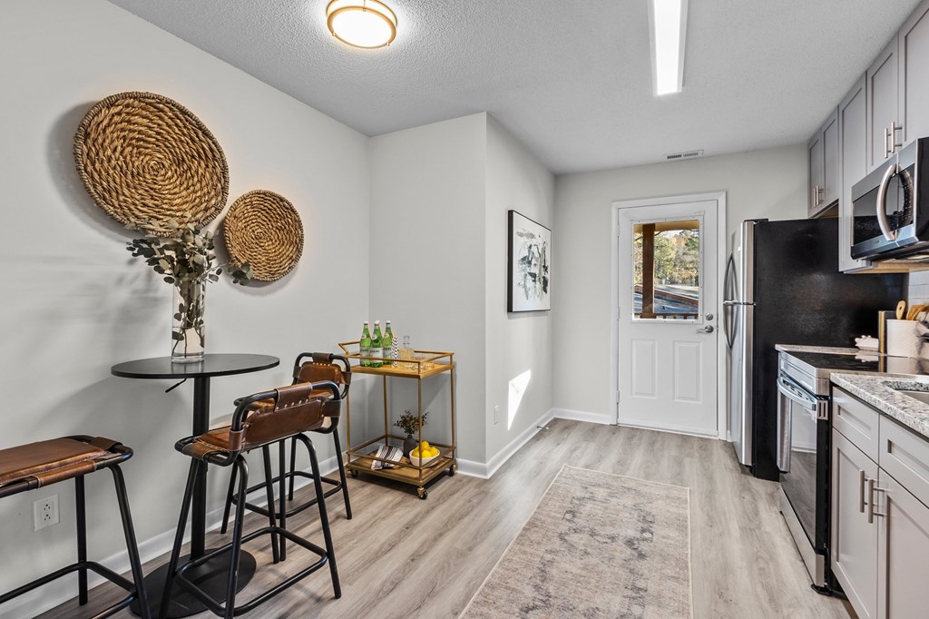 A kitchen with a black fridge and white walls at West Oak Apartments, Wake Forest