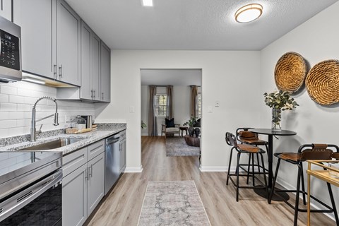 A kitchen with a dining table and chairs.