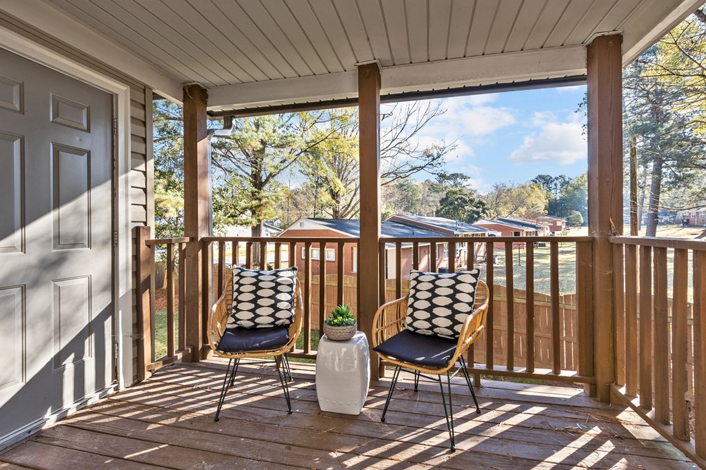 Two chairs on a porch with a pillow on the back of each chair at West Oak Apartments, Wake Forest