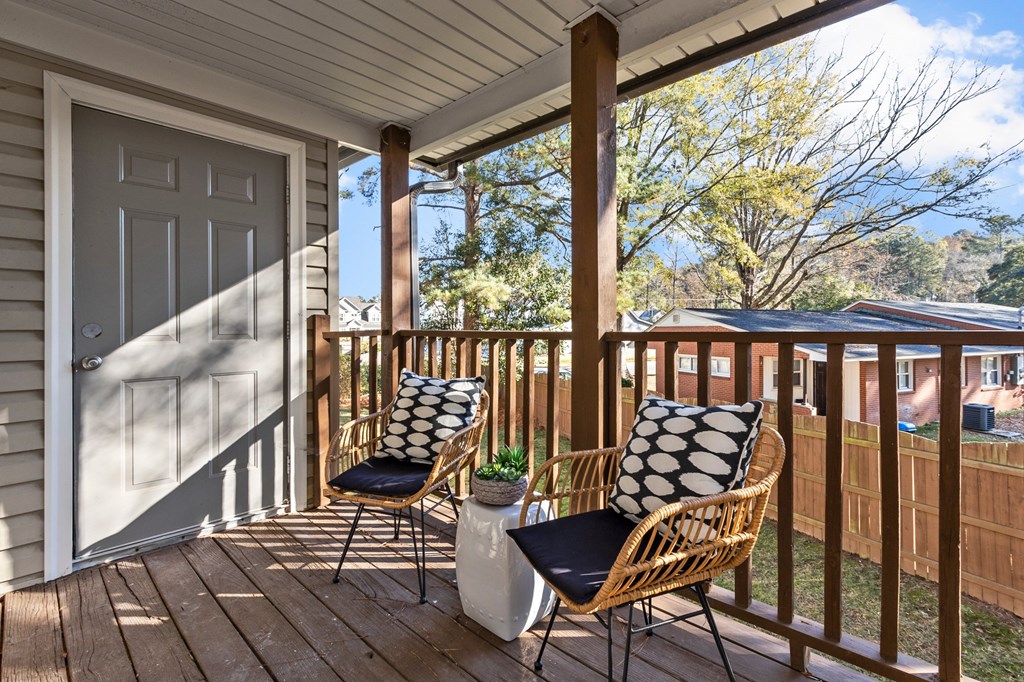 A wooden porch with two chairs and a table at West Oak Apartments, North Carolina 27587