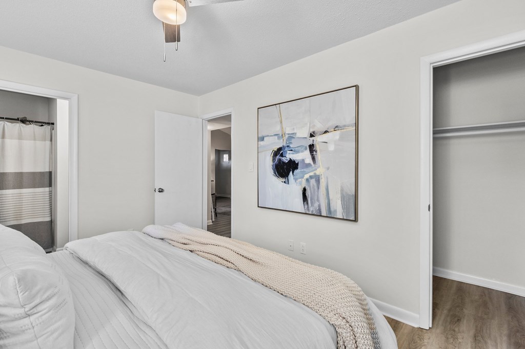 A bedroom with a large bed and a painting on the wall at West Oak Apartments, Wake Forest, NC 27587