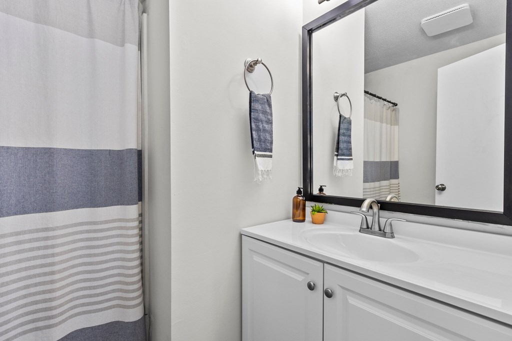 A bathroom with a white sink and a mirror at West Oak Apartments, Wake Forest