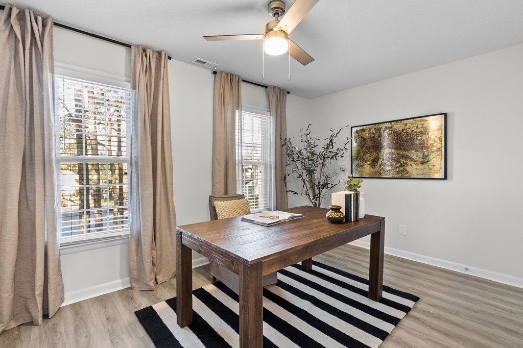 A room with a brown table and a striped rug at West Oak Apartments, Wake Forest, NC