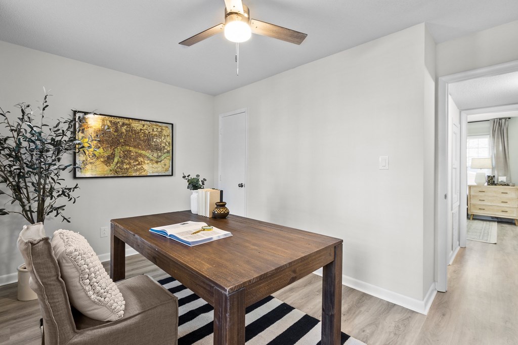 A room with a brown table and a plant on the left side at West Oak Apartments, Wake Forest