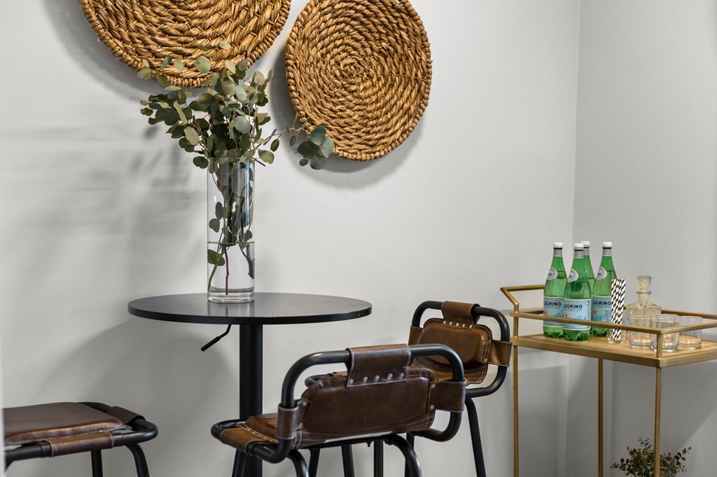 A table with a vase of flowers and two bottles of water on it at West Oak Apartments, Wake Forest, North Carolina