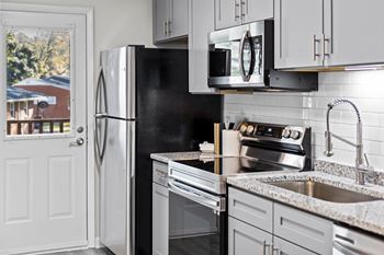 A kitchen with a black fridge and stove at West Oak Apartments, North Carolina 27587