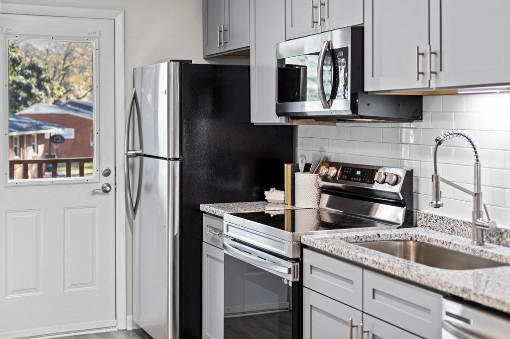 A kitchen with a black fridge and stove at West Oak Apartments, Wake Forest, NC