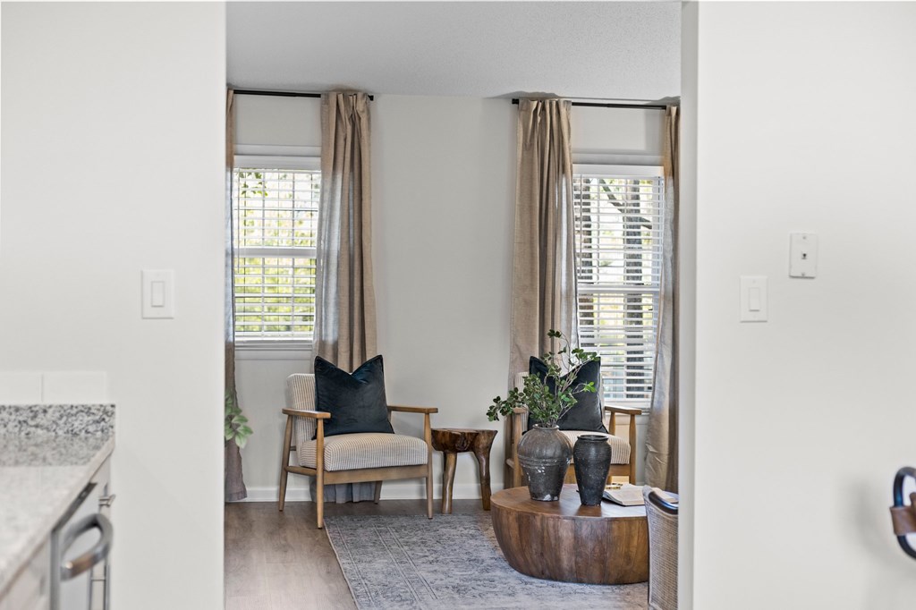 A living room with a chair, a table, and a plant at West Oak Apartments, Wake Forest, NC 27587