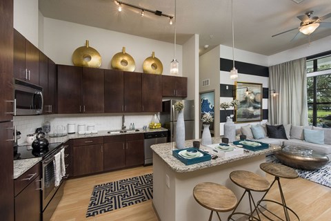 a kitchen and living room with a bar and stools at Azul Baldwin Park, Orlando, 32814