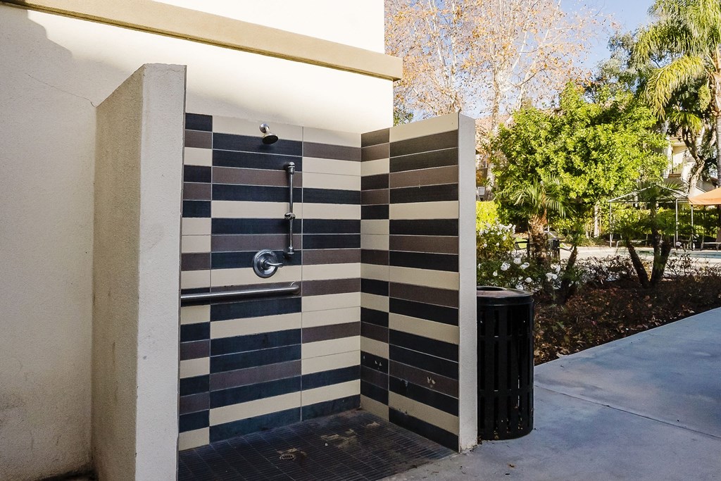 A shower with a black and white tiled wall. at Legends at Rancho Belago, Moreno Valley