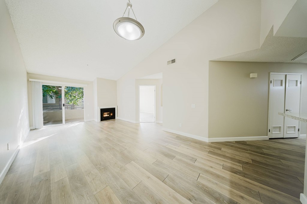 A spacious room with a fireplace and a door leading to another room. at Legends at Rancho Belago, Moreno Valley