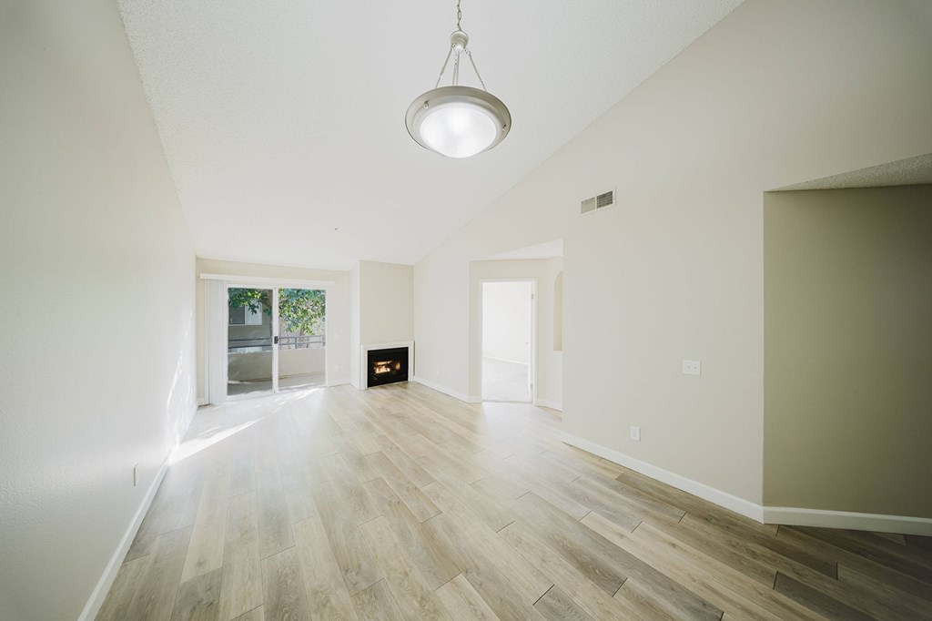 A room with a light hanging from the ceiling and a fireplace in the middle. at Legends at Rancho Belago, Moreno Valley