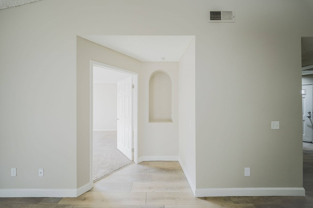 A white hallway with a doorway leading to another room. at Legends at Rancho Belago, Moreno Valley, CA, 92553