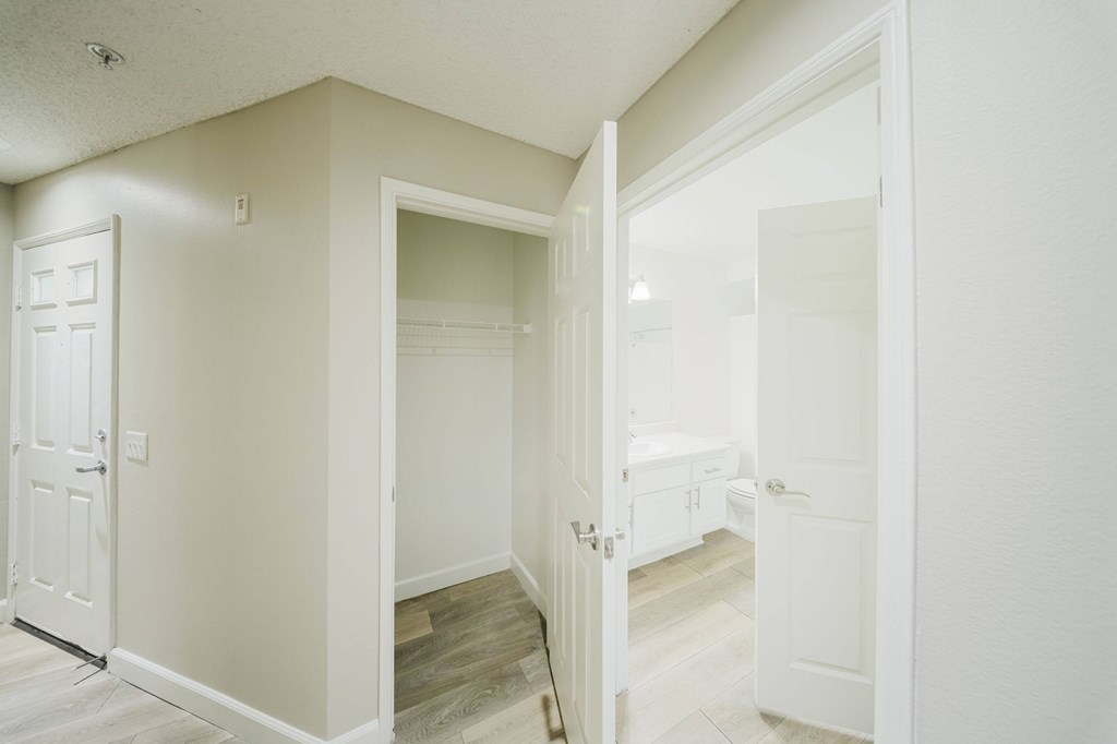 A white door is open to a room with a wooden floor. at Legends at Rancho Belago, Moreno Valley