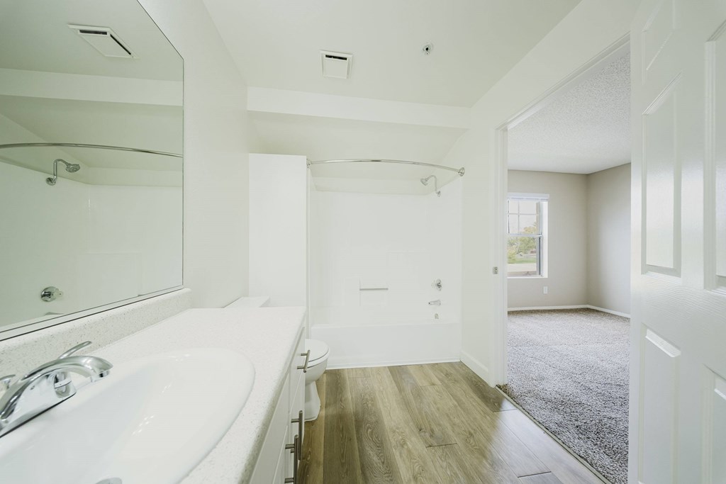 A white bathroom with a tub and a toilet. at Legends at Rancho Belago, Moreno Valley, CA
