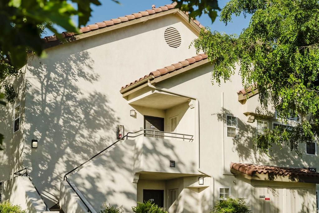 A white building with a red tile roof and a balcony. at Legends at Rancho Belago, Moreno Valley, 92553